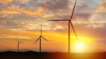 Wind turbines. Silhouettes of windmills at sunset. Wind generators on summer evening. Sustainable energy. Eco power plant. Wind turbines to generate energy. Regenerative energy. Windmills landscape