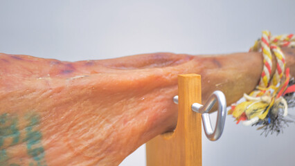 Close-up serrano ham leg paletilla and wood ham holder. Pig hoof