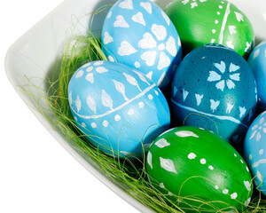 blue and green easter eggs in a white plate
