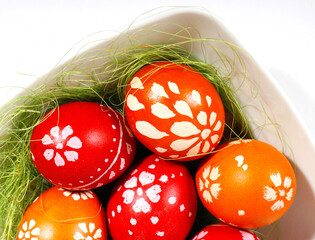 red and orange easter eggs in a white plate
