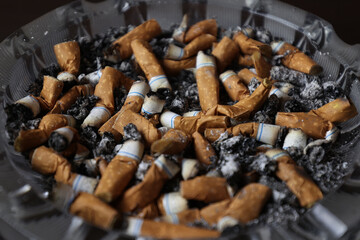 Cigarettes in an ashtray, ashes, many smoked cigarettes. A strong passion for smoking. Harmful to...
