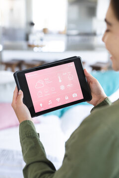 Cropped image of caucasian young woman controlling smart home over digital tablet, copy space