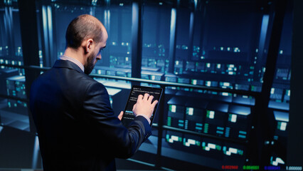 Datacenter engineer using tablet in modern server room, planning cluster computer service or...