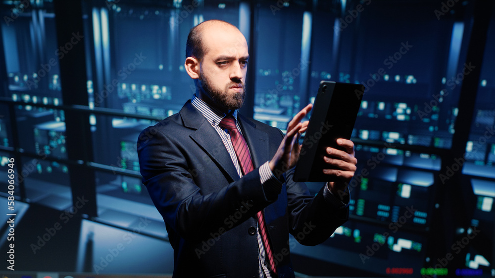 Poster datacenter engineer looking at mainframe diagnostics using digital tablet, inspecting cloud computin