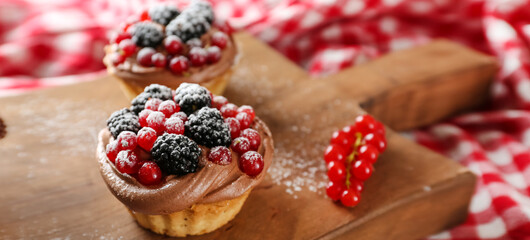 Tasty tartlets with chocolate cream and berries on table, closeup