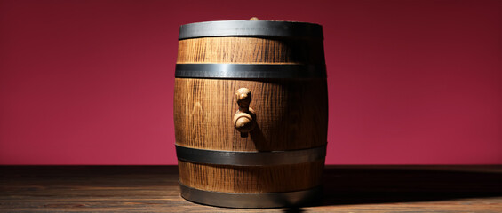 Wooden barrel on table against color background