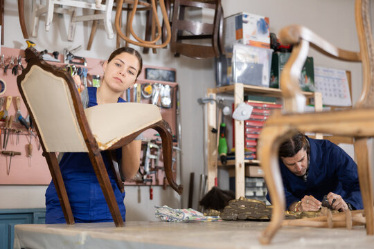 Portrait of skillful repair woman carpenter renovating chair furniture using tools in woodwork studio