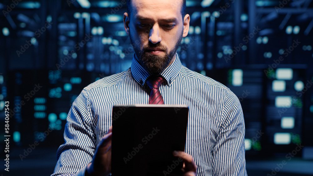 Poster it web technician working in data center with tablet, looking at racks cabinets in digital server ro