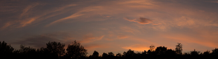 The evening sunset. Panorama. Purple clouds. Tragic gloomy sky.