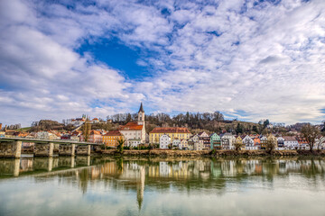 Fototapeta na wymiar High dynamic range cityscape view of Passau city with view at the river inn and Innstadt district with church St. Gertraud in late afternoon sunlight in march