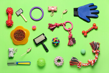 Fototapeta na wymiar Set of pet care accessories and toys on green background