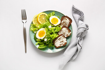 Plate of delicious salad with boiled eggs and cream cheese sandwiches on grey background
