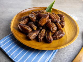 tunisia dates, kurma tunisia on wooden plate for breakfasting in ramadhan. popular and healthy dates 