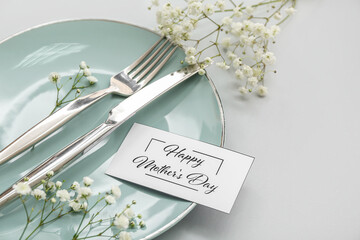 Table setting for Mother's Day celebration with gypsophila flowers on grey background