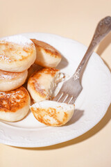 Plate with delicious cottage cheese pancakes on color background, closeup