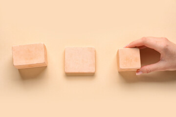 Woman with wooden cubes on beige background