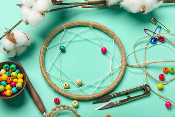 Materials for making dream catcher with cotton flowers on green background, closeup
