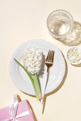 Clean plate with beautiful hyacinth flower on beige background