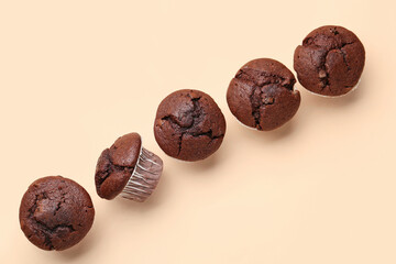 Tasty chocolate cupcakes on beige background