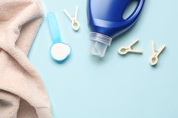 Laundry detergents and clothespins on blue background