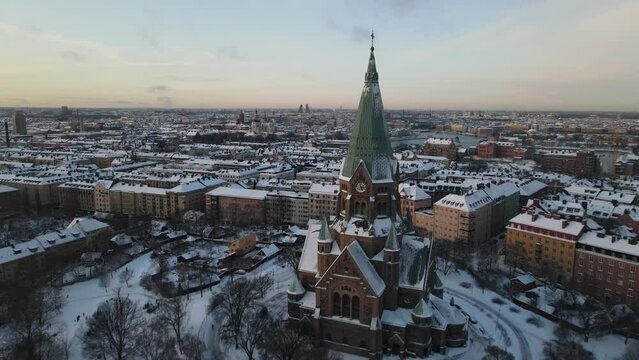 Aerial video above Sofia kyrka church in Stockholm Sweden. The capital city is covered in snow