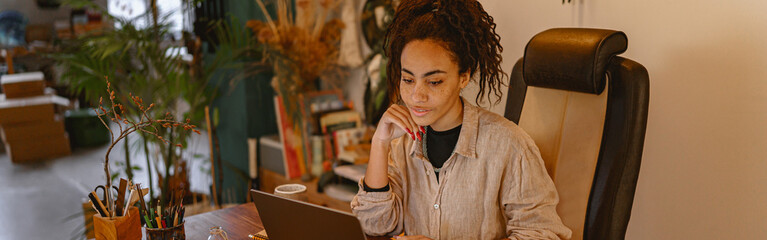 Successful female decorator working online from own art studio and check customers order