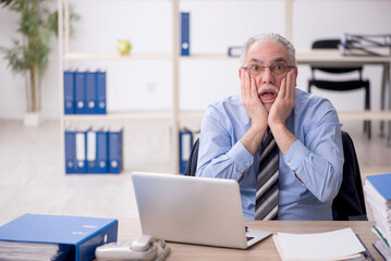 Old male employee working in the office