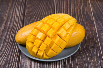 Yellow mango with slice on wooden table.