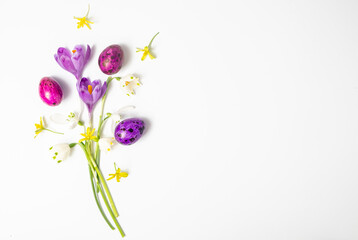 Colorful easter eggs and flowers crocus on a white background. Flat lay, top view and copy space