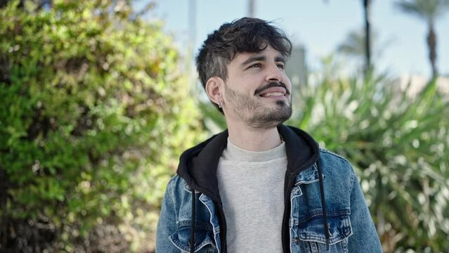 Young hispanic man smiling confident at park