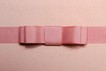 Pink double bow on pink fabric background