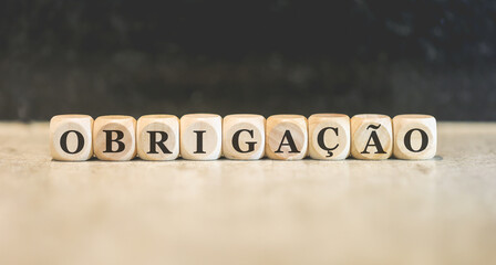 Fototapeta na wymiar A palavra obrigação em Português do Brasil escrita em dados de madeira.