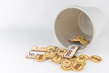 ごみ箱と玩具のお金。無駄遣いのイメージ