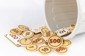 ごみ箱と玩具のお金。無駄遣いのイメージ