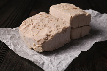 Closeup view of compressed yeast on wooden table