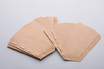 Paper coffee filters on light grey background, above view