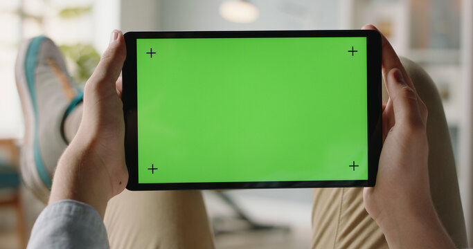 Close up shot of man using a laptop computer, watching video. Green screen mock up chroma key template. Businessman working laptop for new architectural project. Blurred background, horizontal mockup. - Powered by Adobe