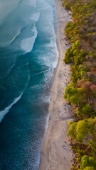 Aerial photography in Costa Rica, beach forest and ocean waves during sunset colors, amazing trip travel