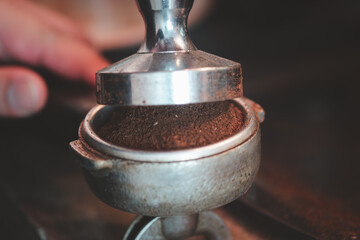 Cropped shot of compression of filter coffee before it is put into the machine. Close up