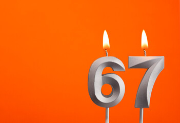 Candle number 67 - Birthday in orange background