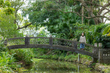 Woman walk in the Japanese green garden