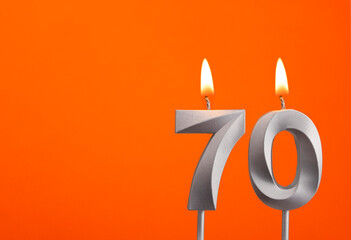 Number 70 - Silver Anniversary candle on orange background