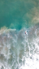 Aerial photography in Costa Rica, surfer alone int the ocean with big waves and amazing colors