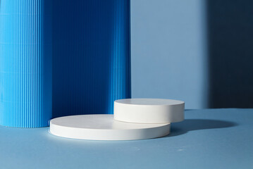 Two empty round white platforms stacked on top of each other, decorated on blue background. Empty...
