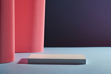 Front view of white rectangle empty podium on dark background. Pink paper folds form a soft...