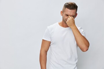 Man runny nose and cough, cold and flu, allergies, pain, in white t-shirt on white isolated background, copy space