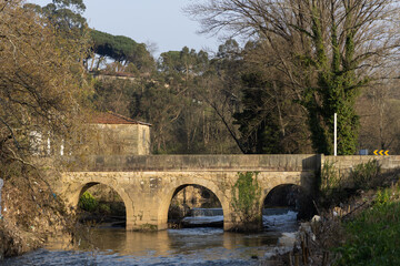 Fototapeta na wymiar Ancient bridge made of stone over the river.