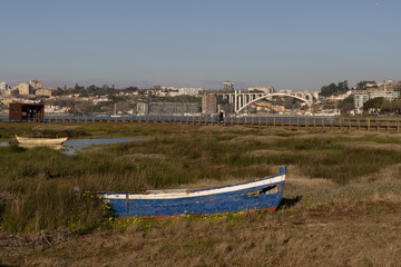 small old blue fishing boat, city in background