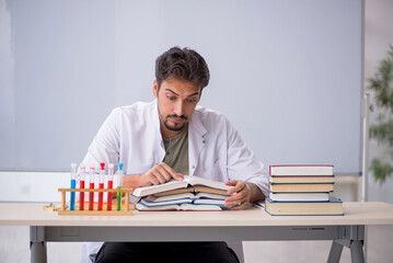 Young male chemist teacher in front of whiteboard