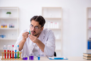 Young male chemist working at the lab